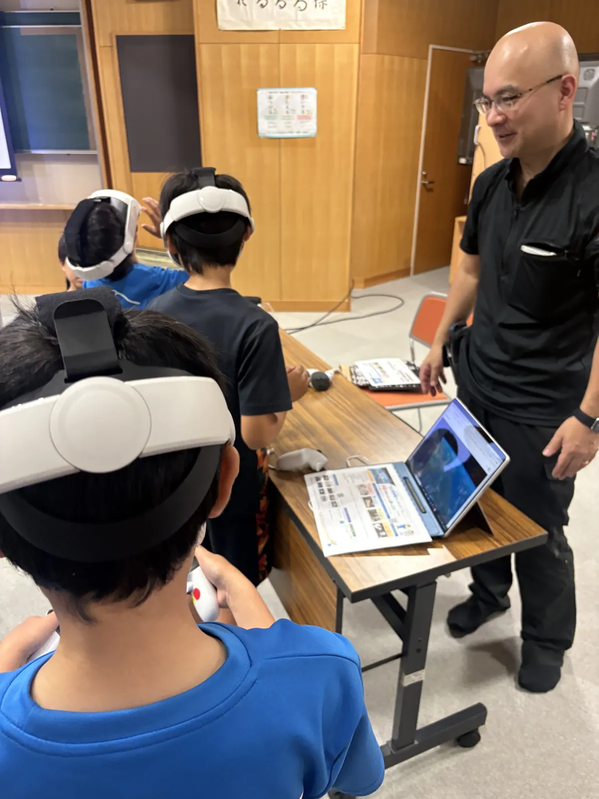 VRゴーグルを着けた児童と、隣でChromebookを使う児童