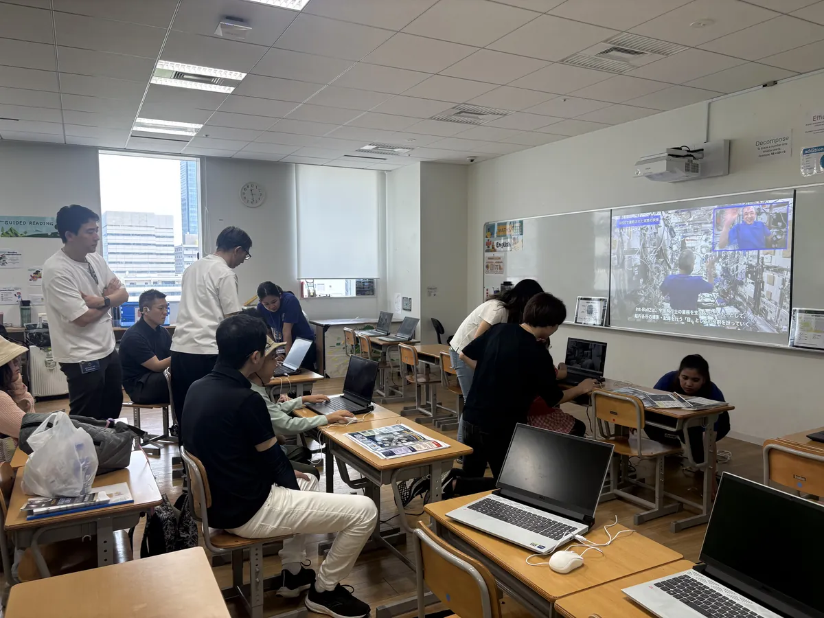 教室のモニターでISSシミュレーターを操作する参加者たち(後ろ姿)