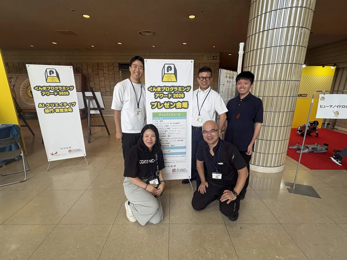 ぐんまプログラミングアワード2026 の会場看板とメンバー